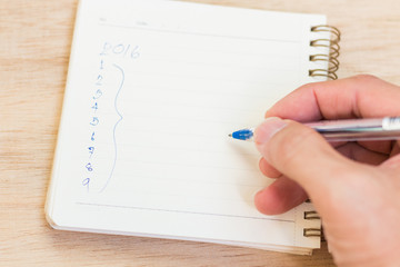 Goals for 2016 - checklist on notepad with pen on wooden backgro