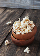popcorn in wooden bowl on a wood background, selective focus