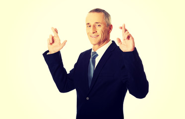 Businessman making a wish with fingers crossed