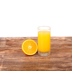 Glass of freshly pressed orange juice with sliced orange half on wooden table