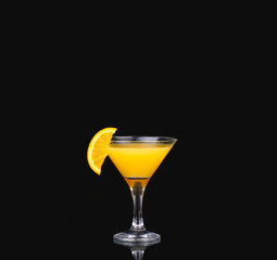 fresh organic orange juice and vodka in a tall glass  on a black background