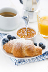 fresh croissant with orange jam, blueberries and coffee 