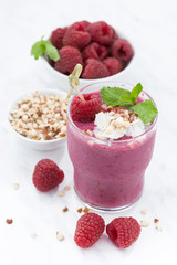 Fresh raspberry smoothie with nuts on white background, closeup