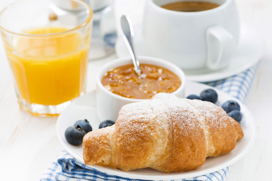 fresh croissant with orange jam, blueberries and coffee 