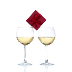 Two champagne glasses and gift on white background