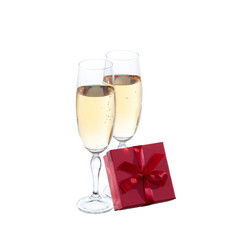 Two champagne glasses and gift on white background