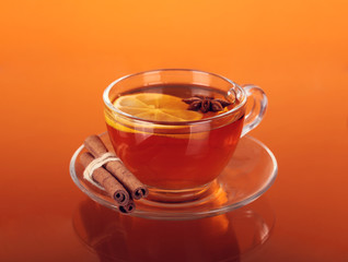 Cup of tea on glass with orange background