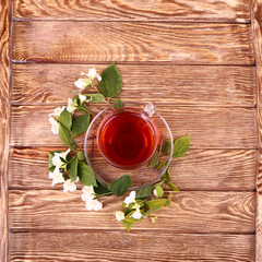 jasmine tea and jasmine flowers on  wooden background, top view