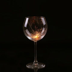 Wine glass with a sparkler. In anticipation of New Year and Christmas