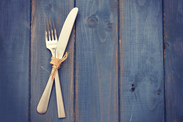 fork and knife on blue wooden background