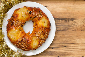 Christmas fruit cake on white plate on brown background