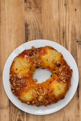 Christmas fruit cake on white plate on brown wooden background