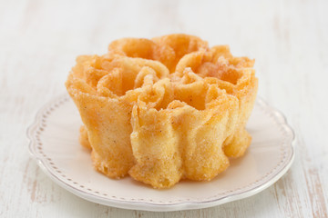typical portuguese dessert filhos on white plate on white wooden background