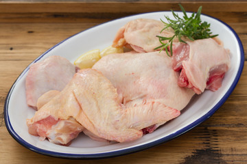 raw chicken on dish on brown wooden background