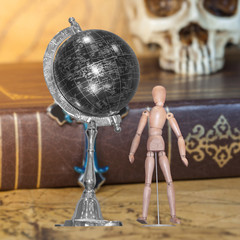 Wooden figure and globe ball on background