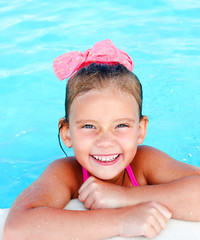 Cute smiling little girl in swimming pool