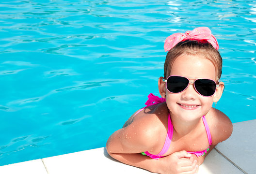 Cute smiling little girl in swimming pool