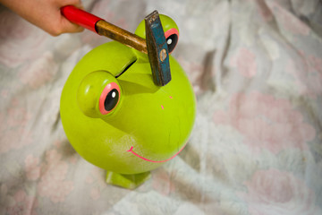 The child wants to break a ceramic piggy bank coin hammer