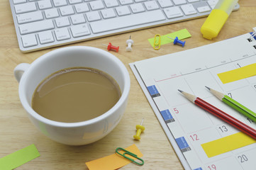 Coffee cup, diary, sticky notes, pencil, pin, clip and keyboard