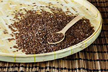 flax seed with spoon placed on flat woven basket
