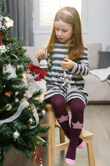 Young girl decorating the Christmas tree