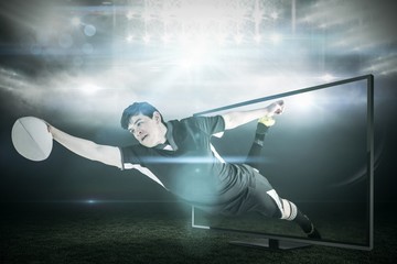 Fototapeta premium Composite image of a rugby player scoring a try