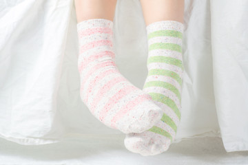 Woman's Feet with Unpaired Striped Socks