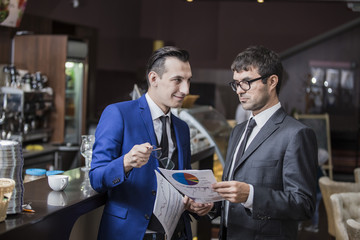 two businessmen communicate happily negotiating in the cafe