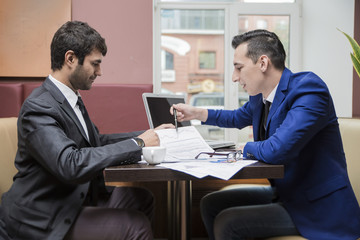 two businessman business partner are negotiating in the cafe