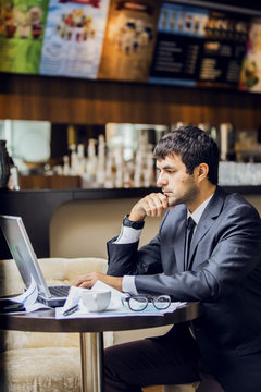 мужчина в деловом костюме с вдохновением работает на ноутбуке