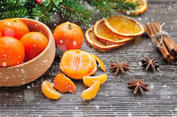 Tangerines and Christmas tree branches on a wooden table. Natural Christmas Decor