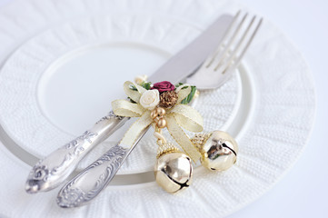 Christmas table setting with fork and knife and christmas decorations on plate