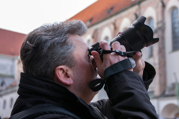 Fotograf schaut durch Sucher seiner Kamera