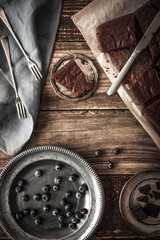 Slices of chocolate brownie with blueberry and vintage dinnerware  vertical