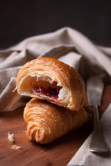 Closeup of croissant with jam on a wooden background. selective focus.