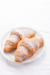 Couple of croissants on a white plate. selective focus.