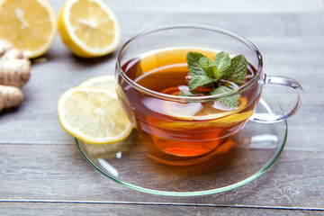 reshly brewed tea in glass cup wooden background
