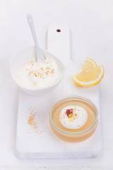 Lemon jelly with cream and jam in a glass on a white board