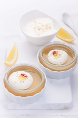 Lemon jelly with cream and jam in a glass on a white board. closeup.