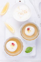 Lemon jelly with cream and jam in a glass on a white board. selective focus