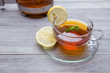reshly brewed tea in glass cup wooden background