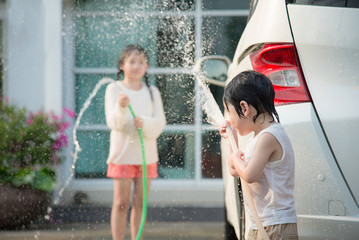 Asian children washing car