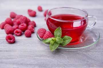 freshly brewed tea in glass cup on wooden background