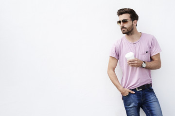 Fototapeta premium Young man posing against white wall, looking away