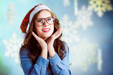 Funny hipster girl in supersize eyeglasses wearing xmas santa hat