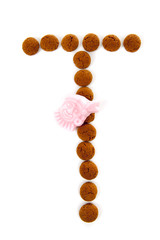 Ginger nuts, pepernoten, in the shape of letter T isolated on wh