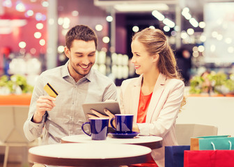 couple with tablet pc and credit card in mall