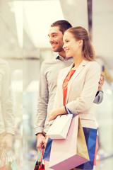 Fototapeta premium happy young couple with shopping bags in mall