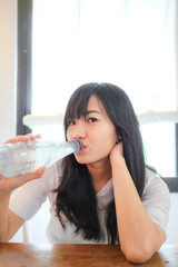 Smiling young business woman drinking water