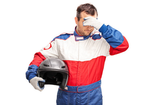 Depressed male car racer holding a helmet